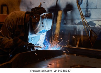 Skilled Welder at Work in Industrial Workshop, Sparks Flying - Powered by Shutterstock