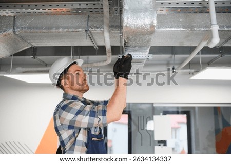 Skilled worker installing hvac system, ensuring proper ventilation and air conditioning in a building under construction