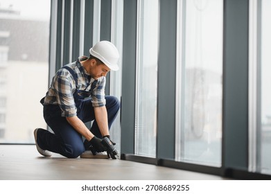 Skilled worker using a power drill, installing windows in a modern building under construction, ensuring precise and secure placement - Powered by Shutterstock - Get 15% off with code: PIKWIZARD15