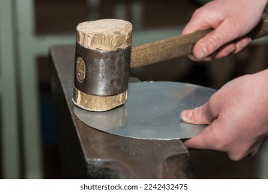 Skilled workers work on sheet metal with hammer - craftsmen in metalworking