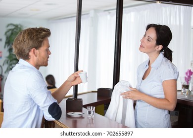 skillful bartender serving client in coffeehouse