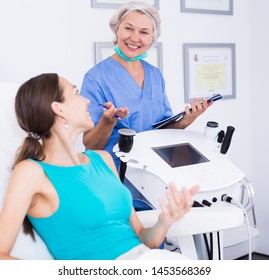 Skillful Cosmetologist Consulting Lady In Medical Esthetic Office