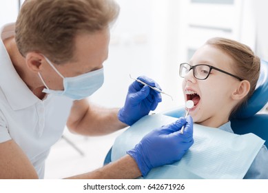 Skillful Dentist Checking A General Condition Of His Patient