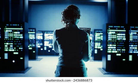 Skillful employee running code on tablet, troubleshooting and upgrading high tech workspace equipment designed to accommodate server units, networking systems and storage arrays