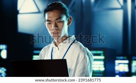 Skillful employee walking through data center systems providing processing resources for different workloads. Admin diagnosing server racks tasked with solving complex operations
