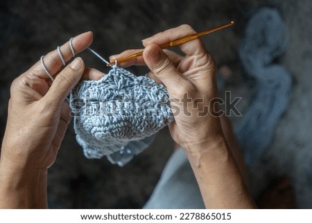 skillful lady using hands and concentrate to knitting thread for personal house use, handmade for crochet , handcraft hobby for relax time in house, prepare local products for weekend farmer market.