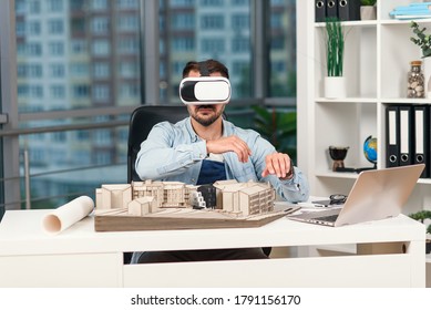 Skillful male architect reviewing architectural project and vr goggles at modern office 