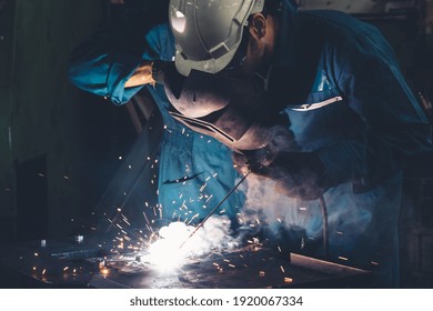 Skillful metal worker working with arc welding machine in factory while wearing safety equipment. Metalwork manufacturing and construction maintenance service by manual skill labor concept. - Powered by Shutterstock