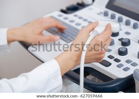 Skillful sonographer using ultrasound machine at work