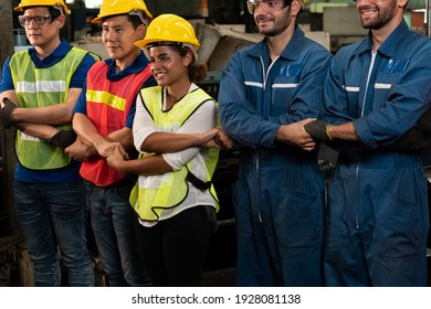 Skillful worker stand together showing teamwork in the factory . Industrial people and manufacturing labor concept .