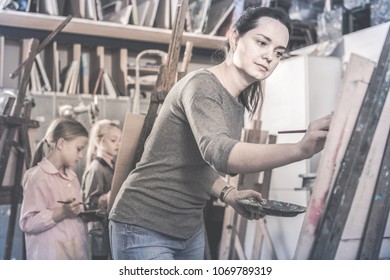 Skillful young cheerful positive students working patiently during painting class at art studio - Shutterstock ID 1069789319