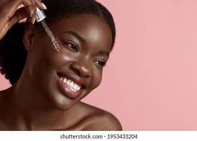 Hautpflege. Schönes Portrait Schwarzer Frauen, die Kollagen-Feuchtigkeitscreme im Gesicht fallen lassen. Modell mit natürlichem Kosmetikprodukt für Hydrat, Glühen und gesundes Gesicht Derma.  Anti-Aging-Therapie