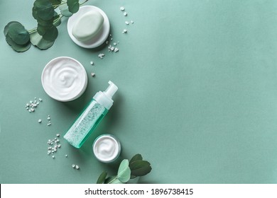 Skin Care, Body Treatment Products, Eucalyptus Leaves, Sea Salt  On Green Background, Top View, Copy Space. Spa And Natural Skin Care Concept.