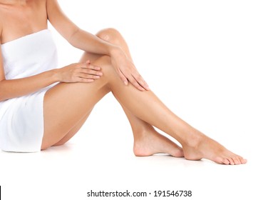 Skin Care. Close up of a perfect female legs. Woman applying moisturizer. 