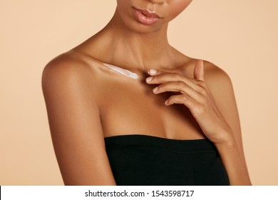 Skin care. Closeup woman's body with cosmetic cream on skin. Beautiful black girl with moisturizing lotion on hydrated body skin at studio - Shutterstock ID 1543598717