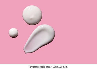 Skin care cream, face serum swatch smear on pink background. Skincare product creamy texture smudge swipe closeup. 