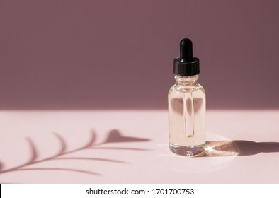 Skin Care Essence Oil Dropper Glass Bottle Pink Background. Hydrating Serum, Vitamin For Face Skin. Aesthetic, Minimalism.