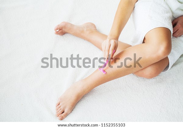 Skin Care and Health. Hair Removal. Fit Woman\
Shaving Her Legs With\
Razor.