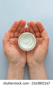 Skin Care Product. Female Hand Holding A Face Cream Jar On Pastel Blue Purple Background. Beauty Skin Care Product Top View