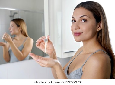 Skin Care Routine. Beautiful Woman Looking At Camera Holding A Pipette In Her Hand With Serum Moisturizing Anti Aging Antioxidant.