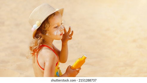 Skin Care. Safe Protection From The Sun. Sunscreen For Children. The Child Holds A Bottle Of Moisturizing Sunscreen In His Hands And Puts A Protective Layer On His Face.