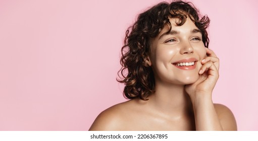 Skin care. Woman with beauty face touching healthy facial skin portrait. Beautiful smiling girl model with natural makeup touching glowing hydrated skin on pink background closeup. - Powered by Shutterstock