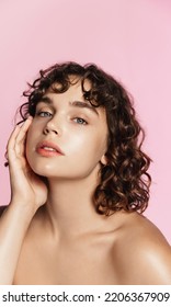 Skin care. Woman with beauty face and healthy facial skin portrait. Beautiful curly girl model with natural makeup touching glowing hydrated skin on pink background closeup. High quality image. - Shutterstock ID 2206367909