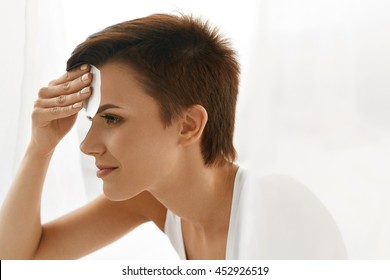 Skin Care. Woman Removing Oil From Face Using Blotting Papers. Closeup Portrait Of Beautiful Healthy Girl With Nude Makeup Cleaning Perfect Soft Skin With Oil Absorbing Tissue Sheets. Beauty Concept