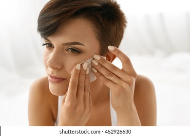 Skin Care. Woman Removing Oil From Face Using Blotting Papers. Closeup Portrait Of Beautiful Healthy Girl With Nude Makeup Cleaning Perfect Soft Skin With Oil Absorbing Tissue Sheets. Beauty Concept
