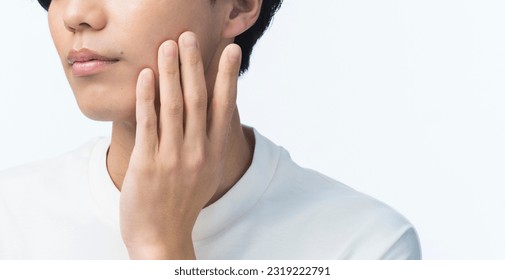 Skin care. A young Asian man has his hand on his chin. Men's beauty. - Powered by Shutterstock