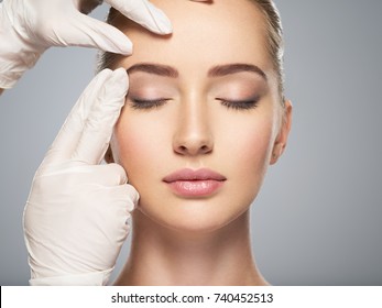 skin check before plastic surgery. Beautician touching woman face.