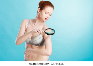 Skin Control Self Examination Concept. Yound Woman Holds Magnifying Glass In Hand Examining Her Body For Melanoma Suspicion. Checking Benign Moles.