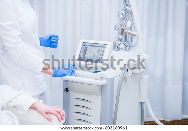 Skin Treatment Laser Equipment. Medical Worker Sets\
Indices On Screen Of Laser for cosmetic procedures. Close up\
Beautician Using Beauty Machine In Cosmetology Center, Beauty\
Salon. Selective focus
