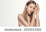 Skincare and Beauty Campaign. Young Beautiful Woman with Radian Skin, applying Cosmetic Product on No Makeup Face, Using Hydration and Collagen Product for Glowy Look, Against White Background.