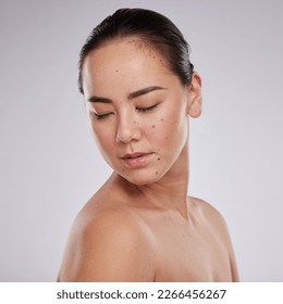 Skincare, beauty and woman in studio for cosmetics, dermatology and skin glow. Aesthetic asian model person with makeup, mole and luxury facial self care for health and wellness on grey background