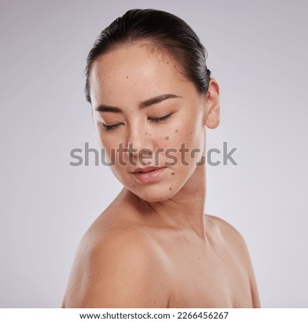 Skincare, beauty and woman in studio for cosmetics, dermatology and skin glow. Aesthetic asian model person with makeup, mole and luxury facial self care for health and wellness on grey background