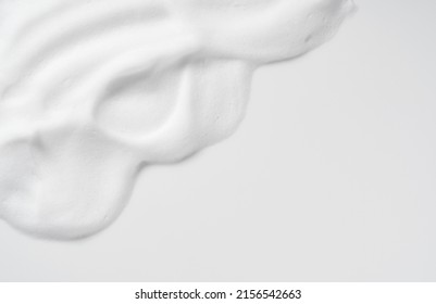 Skincare cleanser foam texture. Copy space and soap bubbles on white background. View from directly above.