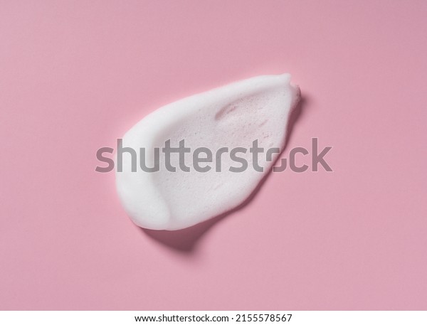 Skincare cleanser foam texture. Swatches\
of soap, shampoo and cleansing mousse foam with copy space on pink\
background. Close-up of facial cleansing\
soap.