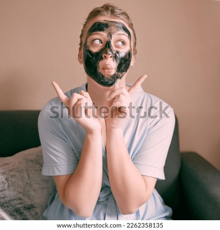 Skincare, face mask and goofy woman in her house, home or apartment doing morning beauty routine with hand gesture. Portrait, relax and funny female doing facial for self care using charcoal