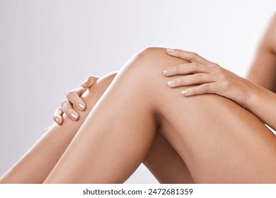 Skincare, legs and woman in studio with closeup, hair removal and hands for wellness or natural beauty. Smooth shave, waxing or laser treatment for body care with girl isolated on white background