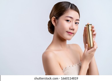 Skincare And Makeup Concept Beautiful Asian Female Woman With Healthy Facial Skin Close Up Portrait Studio Shot Hand Hold Serum Pr Cream Package With Happiness And Joyful