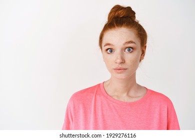 Skincare And Makeup Concept. Close-up Of Clueless Young Redhead Woman Acting Confused, Staring With Blue Eyes At Camera And Shrugging, Standing Over White Background.