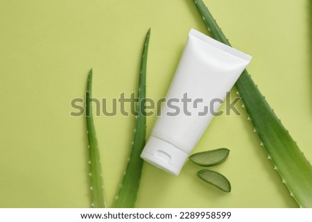 A skincare organic beauty product tube with few Aloe vera leaves and slices. Aloe vera (Aloe barbadensis miller) gel can slow aging of the skin. Mockup design