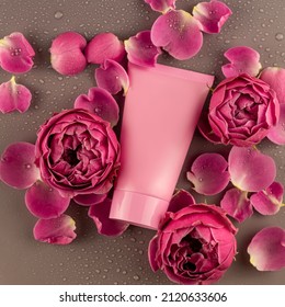 Skincare Products Container On Bright Pink Background With Blooming Rose Flowers. Close Up. Unbranded Package Mockup.