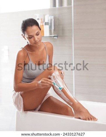 Skincare, razor and woman shaving legs in a bathroom for hair removal, hygiene or smooth skin in her home. Beauty, blade and female person with foam, soap or product for cosmetic, wellness or routine
