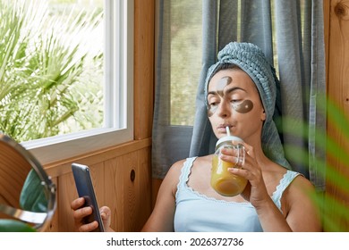 Skincare Routine. Middle Age Woman With Wrinkles And Hydrogel Under-eye Patches Drinking Smoothie And Looking In Window. Lifting Anti-wrinkle Mask Under Eyes. Skincare, Collagen Mask And Spa Concept.