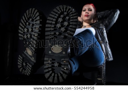 Skinhead boots and sitting woman on black background