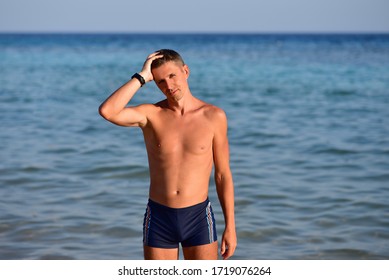 Skinny Eastern European Man In Swimming Trunks At Sea.