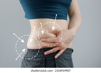 Skinny fat woman figure in fitness clothes touches stomach. Abdominal fat and dieting concept. Massaging marks.