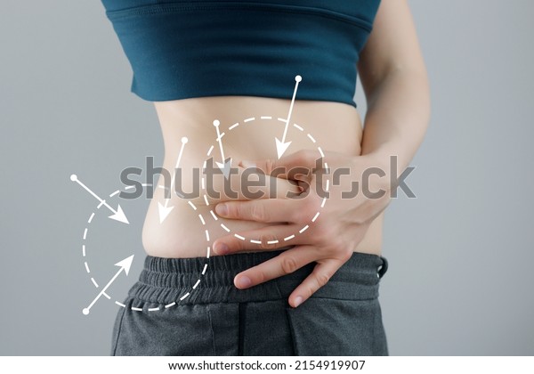 Skinny fat woman\
figure in fitness clothes touches stomach. Abdominal fat and\
dieting concept. Massaging\
marks.